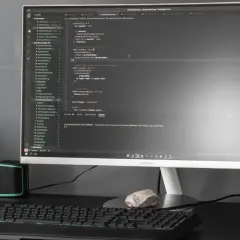 Kod w Visual Studio Code, terminal z komendą dotyczącą `powershell executionpolicy`, obok napój i rośliny.