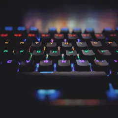 Klawiatura gamingowa z podświetleniem RGB. Każdy klawisz świeci innym kolorem, symbolizując zasadę open-closed principle w kodzie.