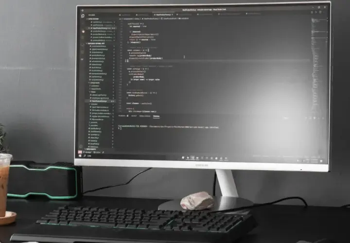 Kod w Visual Studio Code, terminal z komendą dotyczącą `powershell executionpolicy`, obok napój i rośliny.