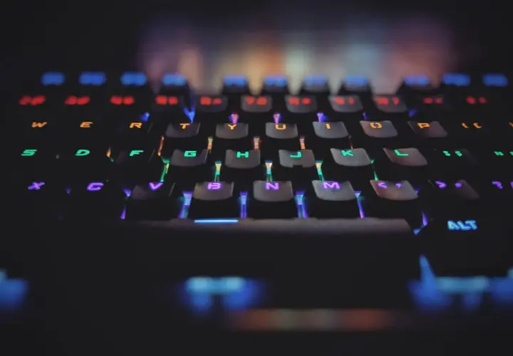 Klawiatura gamingowa z podświetleniem RGB. Każdy klawisz świeci innym kolorem, symbolizując zasadę open-closed principle w kodzie.