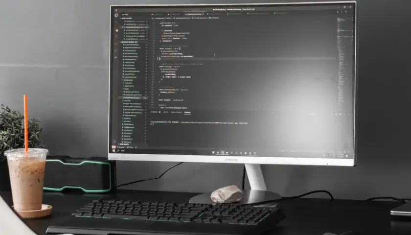 Kod w Visual Studio Code, terminal z komendą dotyczącą `powershell executionpolicy`, obok napój i rośliny.