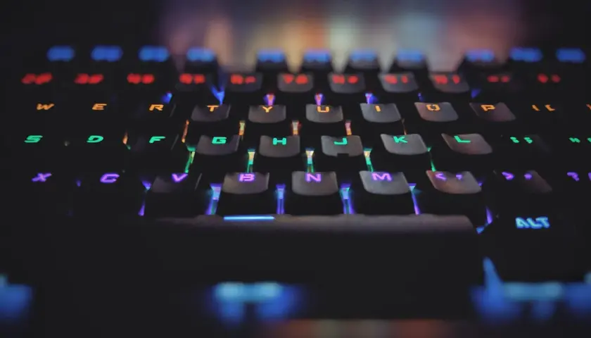 Klawiatura gamingowa z podświetleniem RGB. Każdy klawisz świeci innym kolorem, symbolizując zasadę open-closed principle w kodzie.