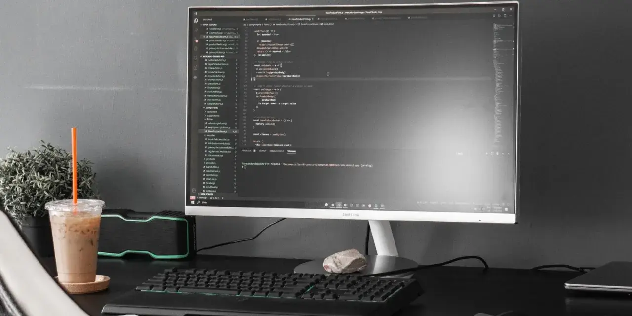 Kod w Visual Studio Code, terminal z komendą dotyczącą `powershell executionpolicy`, obok napój i rośliny.