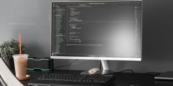 Kod w Visual Studio Code, terminal z komendą dotyczącą `powershell executionpolicy`, obok napój i rośliny.